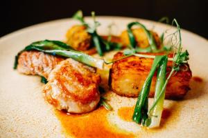 a plate of food with meat and green vegetables at Burlington Hotel, BW Premier Collection by Best Western in Folkestone
