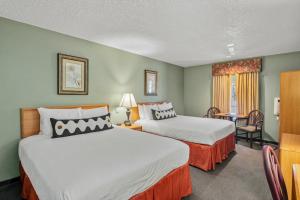 a hotel room with two beds and a table at Old Town Inn in Crested Butte