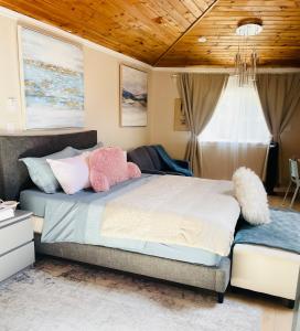 a bedroom with a bed with pink and white pillows at Separate guest suite in Lower Sackville