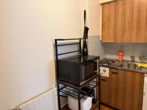 a microwave sitting on a stand in a kitchen at Studio charmant centré à Lausanne in Lausanne