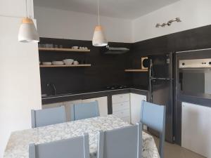 a kitchen with a table and chairs and a refrigerator at MORADIAS I02/C in Prainha