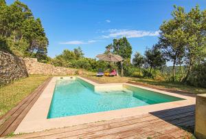 a swimming pool with a table and an umbrella at House Pool Out In The Wilds in Salernes