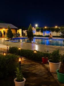 a swimming pool at night with lights around it at Poolside Paradise in Ghaziabad