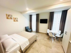 a hotel room with a bed and a table and chairs at Tanushi Central Apartments in Vau i Dejës