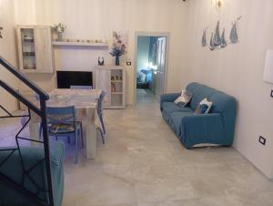 a living room with a table and a blue couch at Astrolicamus, Intero Alloggio con camera e bagno in Bosa