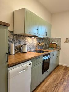 a kitchen with white cabinets and a wooden counter top at Bellevue - mit Balkon und Aussicht in Maring-Noviand +19 photos