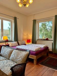 a bedroom with two beds and a couch and windows at Bellevue - mit Balkon und Aussicht in Maring-Noviand