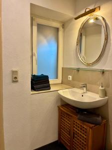 a bathroom with a sink and a mirror and a window at Bellevue - mit Balkon und Aussicht in Maring-Noviand