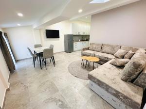 a living room with a couch and a table at Tanushi Central Apartments in Vau i Dejës