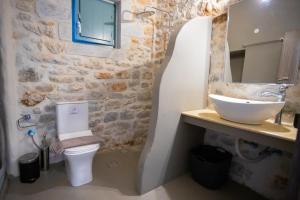 a bathroom with a white toilet and a sink at Mainotti's house with balcony in Areopoli +17 photos