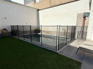 a fence with a swimming pool in a backyard at Casa Pago del Serrallo, a 30 min de Puy du Fou in Santa Olalla de Toledo