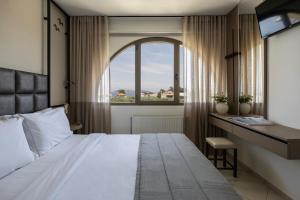ein Schlafzimmer mit Bett, Schreibtisch und Fenster in der Unterkunft Maryan in Limenas + 130 Fotos