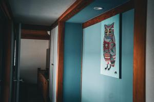 a hallway with a painting of a cat on the wall at ウエダハウス in Ueda