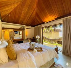 a bedroom with a large bed with a large window at Kuarasy Pousada de Charme Japaratinga in Japaratinga +70 photos
