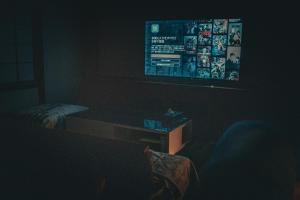 a dark living room with a tv and a couch at ウエダハウス in Ueda