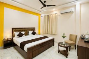 a bedroom with a bed and a desk and a chair at Kanha Green in Habībganj +6 photos