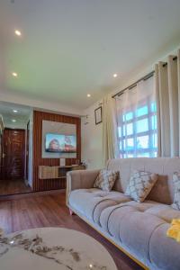 a living room with a couch and a tv at Maya Stays in Busia