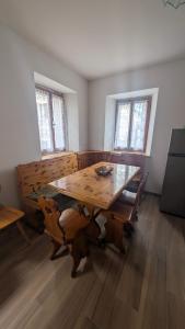 a dining room with a wooden table and chairs at Appartamento al Quadrato in Lorenzago
