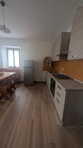 an empty kitchen with a stove and a counter top at Appartamento al Quadrato in Lorenzago +1 photo