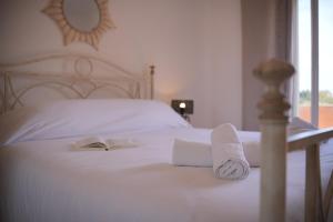 a bed with two towels and a book on it at U Paesolu in Sainte-Lucie de Porto-Vecchio