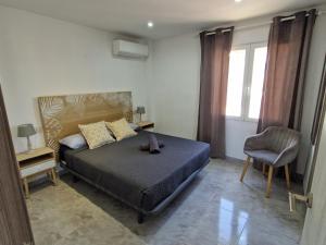 a bedroom with a bed and a chair at Villa Brisamar - On the beach in Peniscola