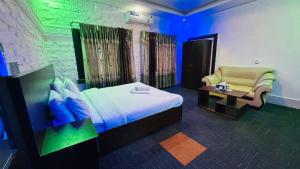 a hotel room with a bed and a chair at Hotel Marvellen Inn Ltd in Dhaka