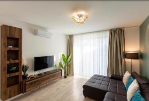 a living room with a couch and a flat screen tv at Lakeside Apartment Sunset Resort in Fonyód