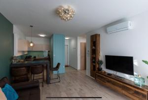 a living room with a flat screen tv and a kitchen at Lakeside Apartment Sunset Resort in Fonyód