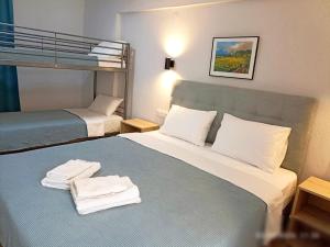 a hotel room with a bed with towels on it at ATHINA MARE-SOLE in Kallithea Halkidikis