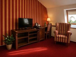a hotel room with a desk with a television and two chairs at Hotel ZÁMOCKÁ KORUNA u Hoffera in Nitra
