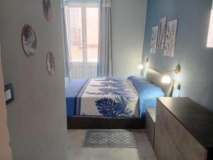 a bedroom with a bed and a dresser and a window at Astrolicamus, Intero Alloggio con camera e bagno in Bosa
