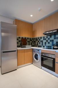 a kitchen with a stainless steel refrigerator and a dishwasher at Zephyr Martil in Martil