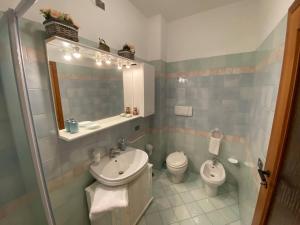 a bathroom with a sink and a toilet and a mirror at Casa Vignetto Biella in Biella +14 photos
