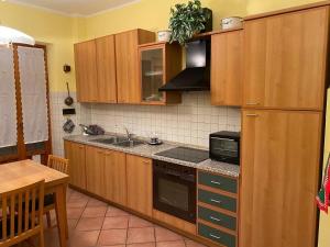 a kitchen with wooden cabinets and a stove top oven at Casa Vignetto Biella in Biella