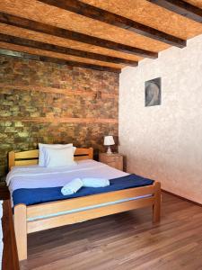 a bedroom with a bed and a brick wall at Vuk Etno domaćinstvo in Barajevo +24 photos