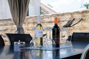 two bottles of wine sitting on a table with glasses at Kathy House in Slatine +28 photos