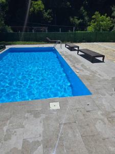 a blue swimming pool with a bench in a yard at Vuk Etno domaćinstvo in Barajevo