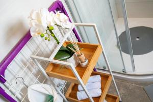 a shelf with flowers and towels in a bathroom at Kathy House in Slatine