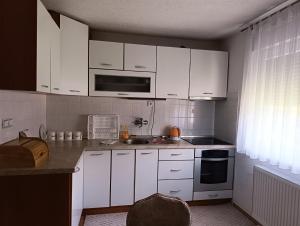 a kitchen with white cabinets and a sink at Apartmani Srebrenik in Srebrenik