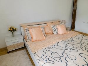 a bedroom with a bed with pink pillows and a table at Apartmani Srebrenik in Srebrenik