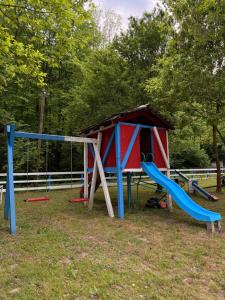 a playground with a house and a slide at Vuk Etno domaćinstvo in Barajevo