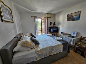 a bedroom with a bed and a couch and a television at Animari Apartments in Stari Grad