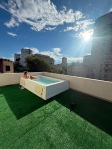 a child sitting in a hot tub on a rooftop at Uvas Apart Hotel in Mendoza