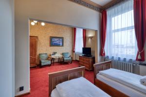 a bedroom with two beds and a table and chairs at Hotel Continental in Pilsen