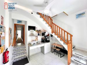 a staircase in a house with a kitchen and a table at Pensión RENCH in Alcossebre