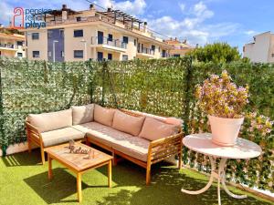 a patio with a couch and a table and flowers at Pensión RENCH in Alcossebre
