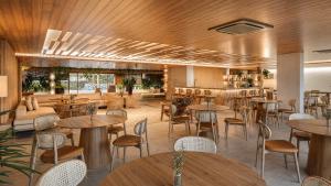 a restaurant with wooden ceilings and tables and chairs at Beach Park Resort - Ohana in Aquiraz