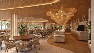 a restaurant with tables and chairs and chandeliers at Beach Park Resort - Ohana in Aquiraz