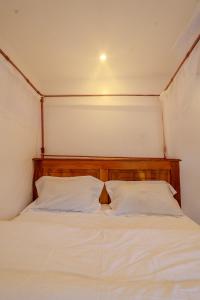 a bed with two white pillows in a room at Maya Stays in Busia