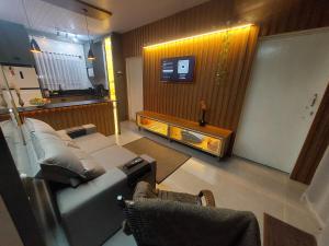 a living room with a couch and a tv at Villa Pitanga Pousada in São Martinho